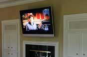 TV mounted above the fireplace in the master bedroom. Expertly installed by HiFi Doc